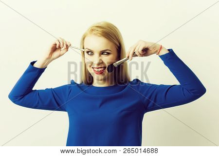 Girl Squinting Eyes On Silly Face With Makeup Brushes. Funny Woman Grinning With Crossed Eyes And Lo