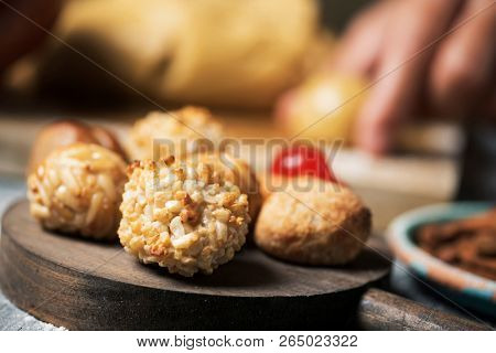 closeup of a young caucasian man preparing some panellets, sweet food typically eaten in All Saints Day in Catalonia, Spain