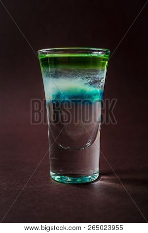 Clouds Alcoholic Shot Glass With Absent, Sambuca, Tequila, Blue Curacao On Elegant Dark Brown Backgr