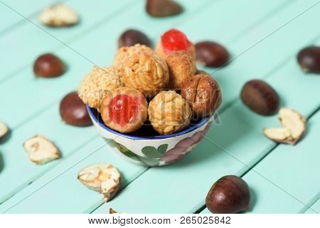 closeup of some chestnuts and some panellets, as a typical snack eaten in All Saints Day in Catalonia, Spain, called castanada