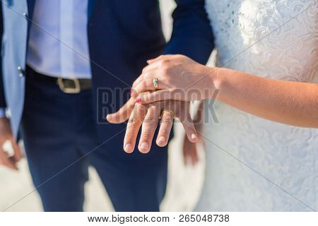 Closeup Of A Couple Exchanging Wedding Rings During A Wedding Ceremony On The Beach. Destination Wed