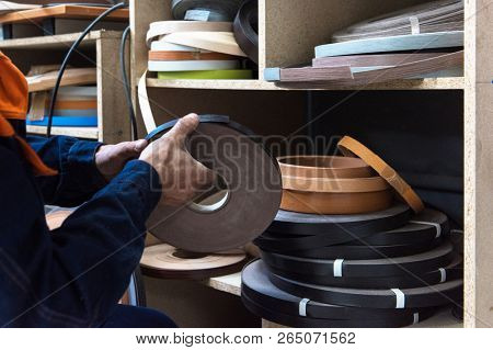 Furniture production concept: man working at furniture factory