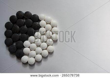 Iron (black) And Vitamin K (white) Pills In Shape Of Yin And Yang Symbol
