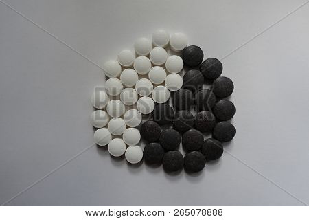 Top View Of Yin And Yang Symbol Formed Of Black And White Round Pills