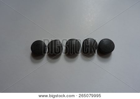 Row Of Five Round Black Tablets Of Chelated Iron