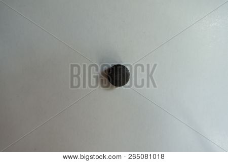 Top View Of Round Black Pill Of Chelated Iron
