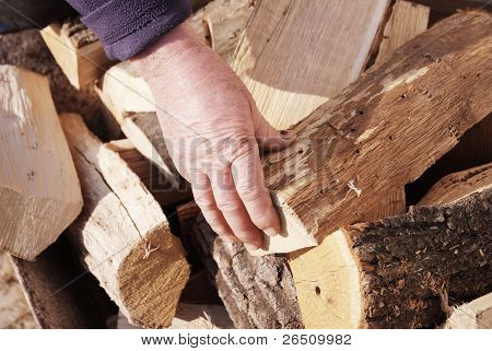 hand of worker on a stack of wood