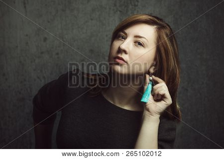 Vintage Portrait Of Beautiful Stylish Girl With Turquoise Earrings On Gray Studio Background.