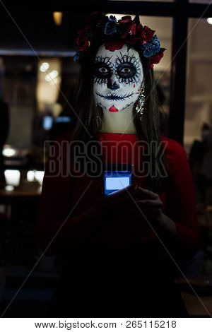 A Girl With A Painted Face Of A Skeleton, A Dead Zombie, In The City During The Day. Day Of All Soul
