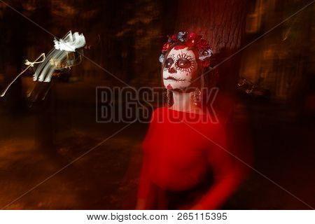 Blurry Body And Red Lantern. A Girl With A Painted Face Of A Skeleton, A Dead Zombie, In The City Du