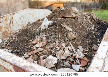 Container Filled With Construction Waste Close Up Shot On Natural Light.