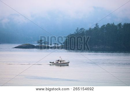 October 9, 2018 In Salt Spring Island, Bc:  Fishing Motor Boat Riding Beside The Rugged Coast With S