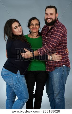 Adult Son And Daughter Hugging Mom Isoolated On Gray Studio Background