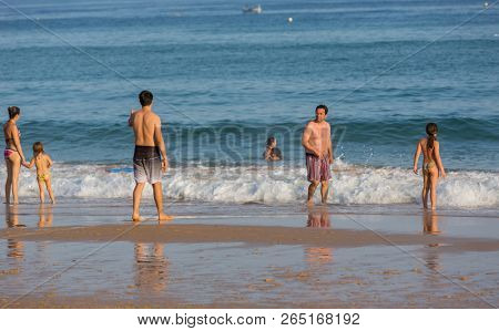 VILA DO BISPO, PORTUGAL - AUGUST 21, 2018: People at the famous beach of Salema in Vila do Bispo. This beach is a part of famous tourist region of Algarve.