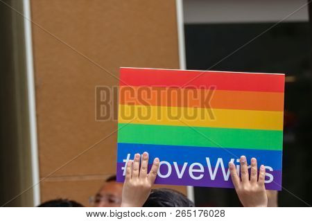 2017 May 08. Tokyo Japan. Human Hand Holding Lgbt Rainbow Flag With Lovewins Hastage And Walking Aro