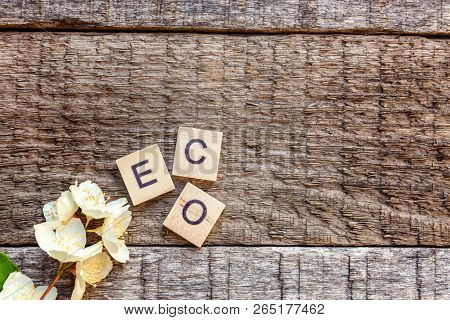 Inscription Eco Letters Word Jasmine Flower On Old Rustic Wooden Backdrop. Eco Village Abstract Envi