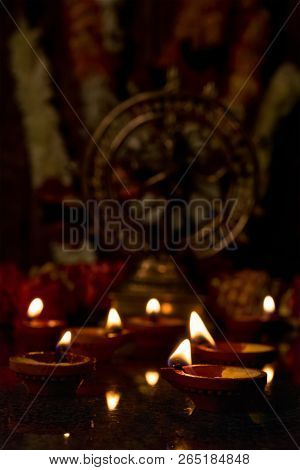 Diwali lights oil candles with Shiva Nataraja in the background for Maha Shivaratri,  India