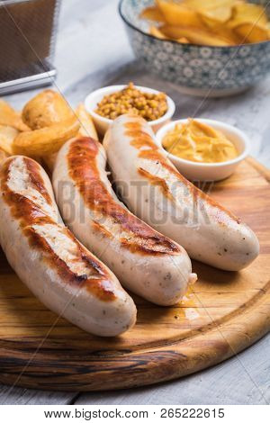 Grilled german sausages with mustard and fried potato chips