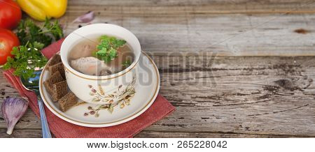 Clear Beef Broth, Bouillon In White Bowl And Vegetables On Wooden Table. Rustic Style. Copy Space. B