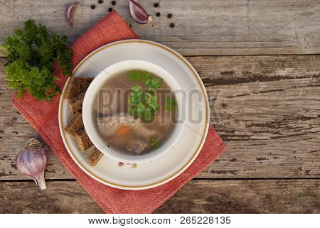 Clear Beef Broth, Bouillon In White Bowl And Vegetables On Wooden Table. Rustic Style. Top View.