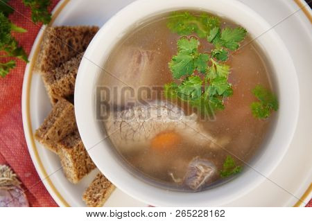 Clear Beef Broth, Bouillon In White Bowl And Vegetables On Wooden Table. Rustic Style. Top View.