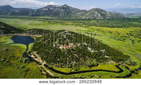 Aerial View Of The Landscape Of Lake Skadar In The Mountain And The Island With Monastery On A Beaut