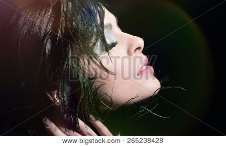 Portrait of a young girl with evening make-up and feather decora