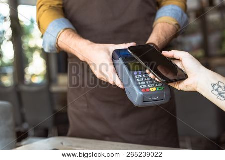 Cropped Shot Of Waiter Holding Payment Terminal While Customer Doing Contactless Purchase With Smart
