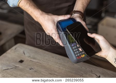 Cropped Shot Of Waiter Holding Payment Terminal While Customer Doing Contactless Purchase With Smart