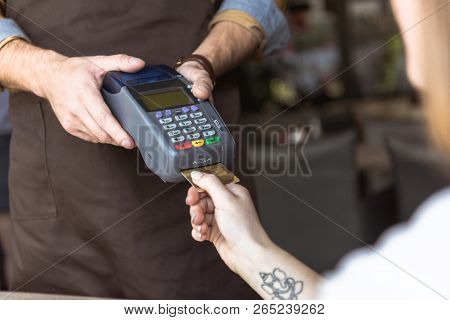 Cropped Shot Of Waiter Holding Payment Terminal While Customer Inserting Credit Card