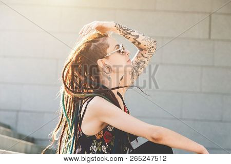 Young Girl With Tattoo And Dreadlocks Sitting On The Steps