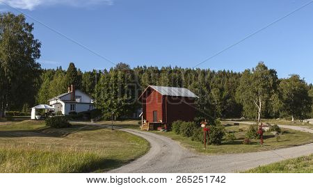 Medelpad, Sweden On 05. View Of Some Buildings, Driveways Signs And A Forest In The Background On Ju