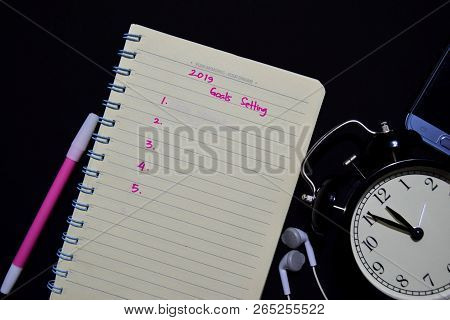 Notebook, Smartphone, Earphone And Color Pen With Selective Focus 2019 Goals Setting Text In Black B