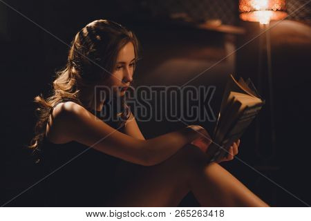 Sensual Young Woman With Long Brown Hairs Sitting In Black Sexy Lingerie Under Bookshelf Looking In 