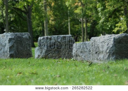 Four Rocks In The Grass In The Park On A Sunny Afternoon