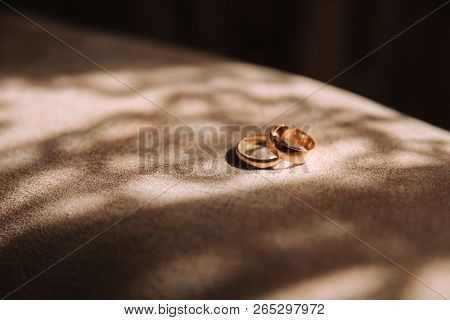 Wedding Rings In Gooms Home. The Sun Rays Fall On The Rings