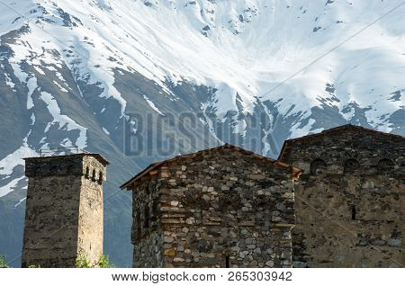 Traditional Svanetian Towers On The Background Of The Snow-covered Caucasus Mountains.