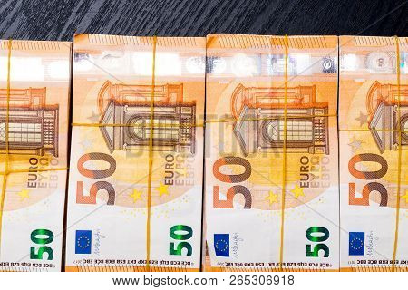 Pile Of 50 Real Euro Notes 50-euro Banknotes Under Rubber Band Isolated On Black. About 20000 Euros 