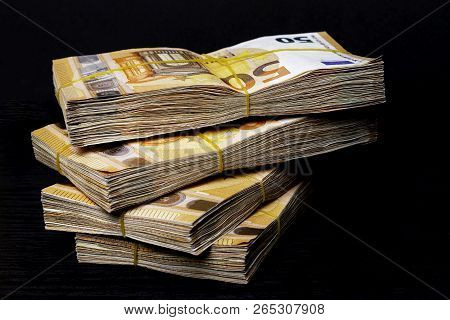 Pile Of 50 Real Euro Notes 50-euro Banknotes Under Rubber Band Isolated On Black. About 20000 Euros 
