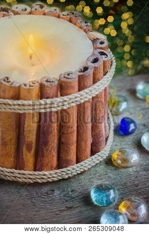 Candlestick Of Cinnamon Sticks With Christmas Decoration And Branch Of Fir Background With Bokeh.