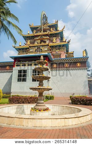 Bylakuppe, Karnataka, India - January 9, 2015: Multileveled Fountain Near The Entrance Temple Buildi