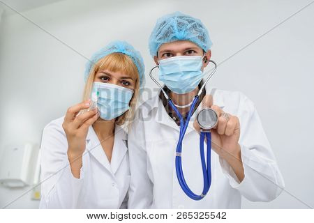Two Doctors With The Masck, Stethoscope In Hand And Injection, Close View