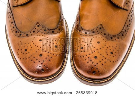 A Close-up Shot Of A Pair Of Mens Brown Wingtip Dress Shoes On An Isolated Background