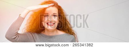 Charming Young Girl With Red Hair. A Young Girl In A Gray Sweater. Young Girl On A Gray Background. 