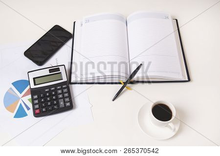 Calculator With Notepad And Phone On Desk