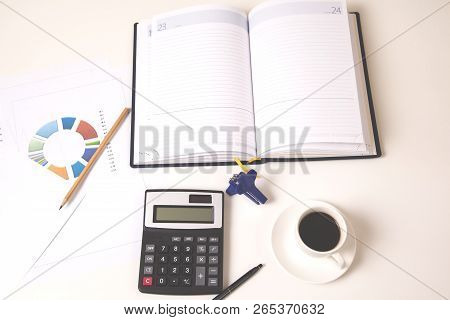 Calculator With Notepad And Coffee On Desk