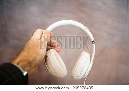Paris, France - Oct 26, 2018: Man Holding Against Stone Bakground Wall A Pair Of Apple Beats By Dr D