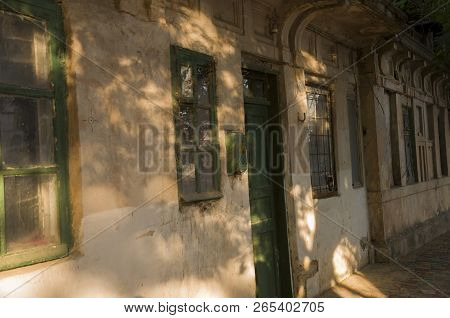 Old Destroyed Stone House On The Yard With Trees Around. Poverty And Misery, South, Summer
