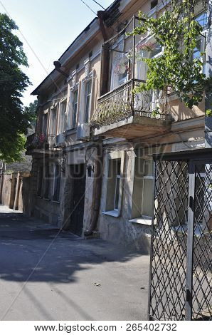 Old Destroyed Stone House On The Yard With Trees Around. Poverty And Misery, South, Summer