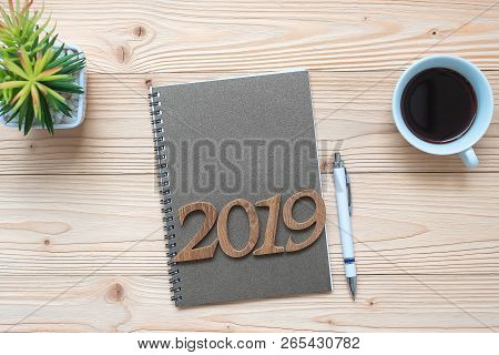 2019 Happy New Year With Notebook, Black Coffee Cup, Pen And Glasses On Wooden Table, Top View And C